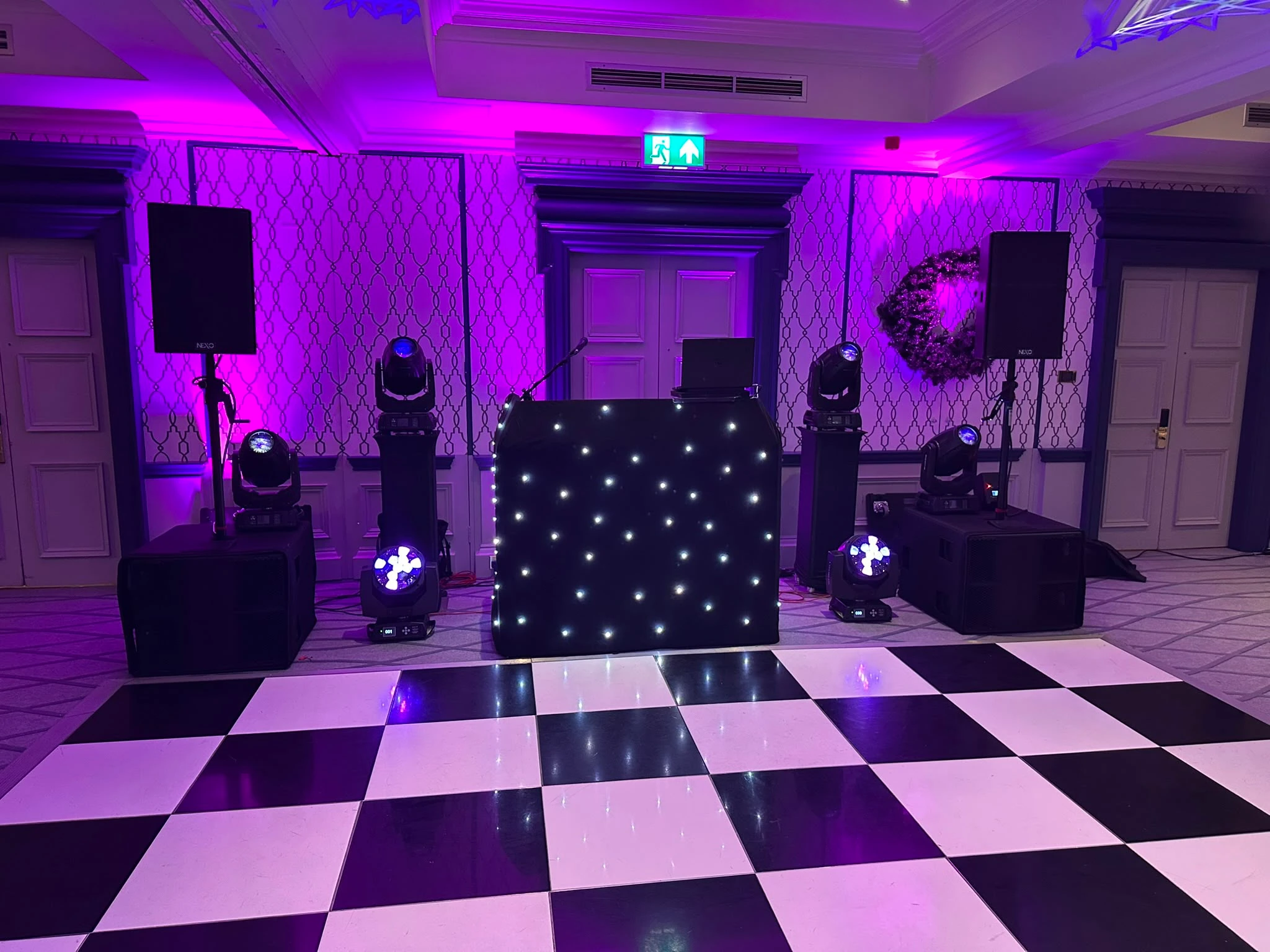 Black star booth above a purple-washed checkerboard floor