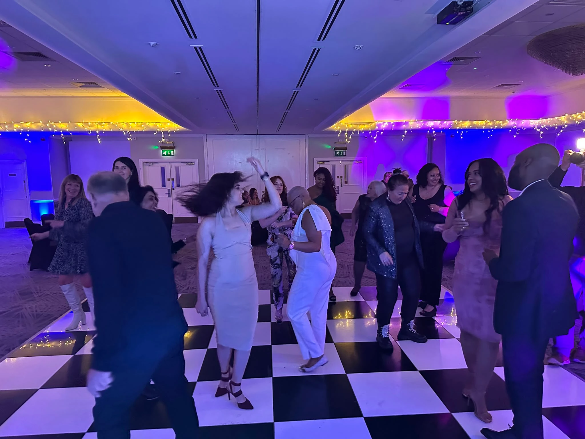 Dancing on a checkerboard floor beneath the chandeliers