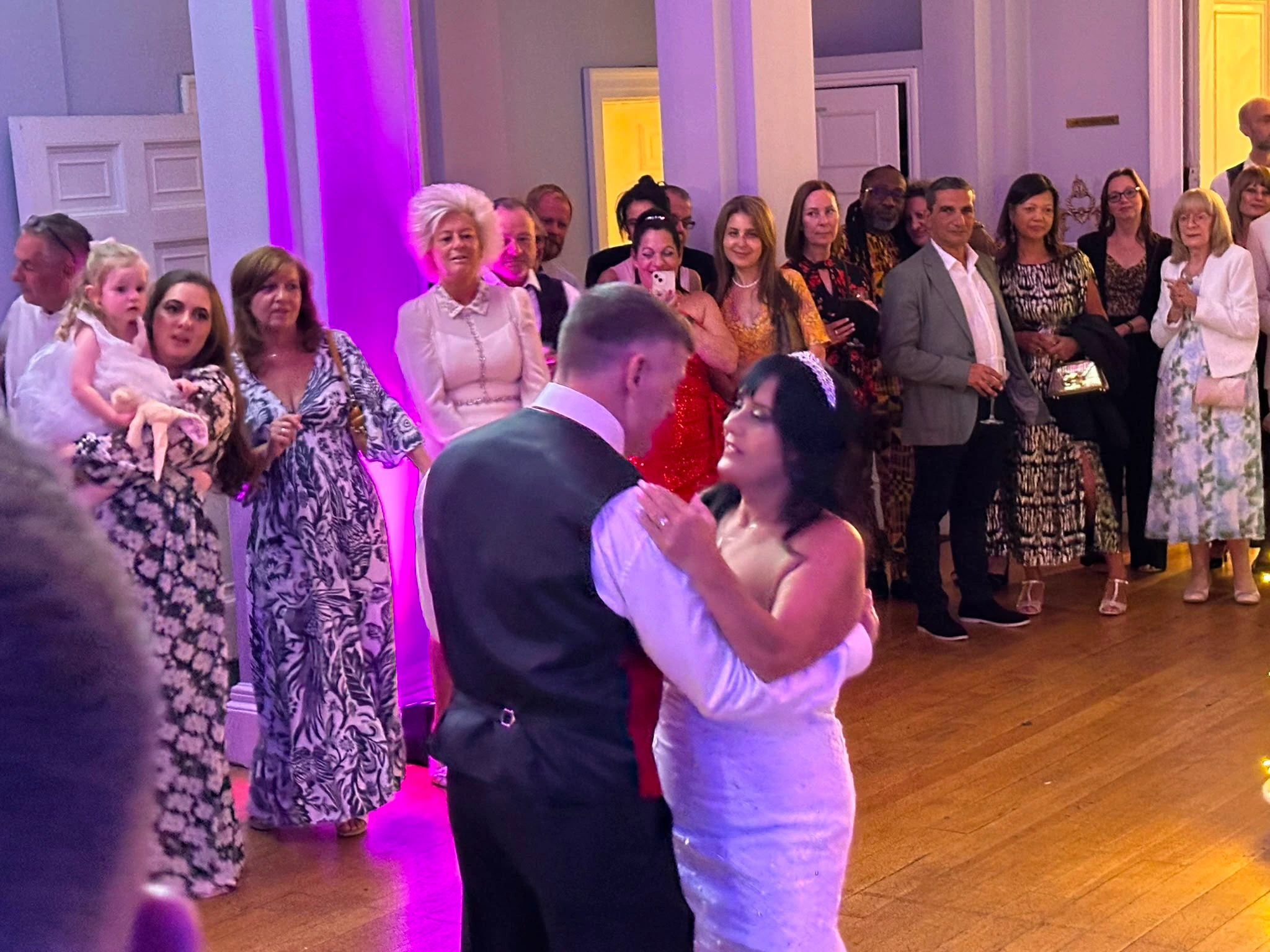 First dance in a bright Georgian room, guests gathered round
