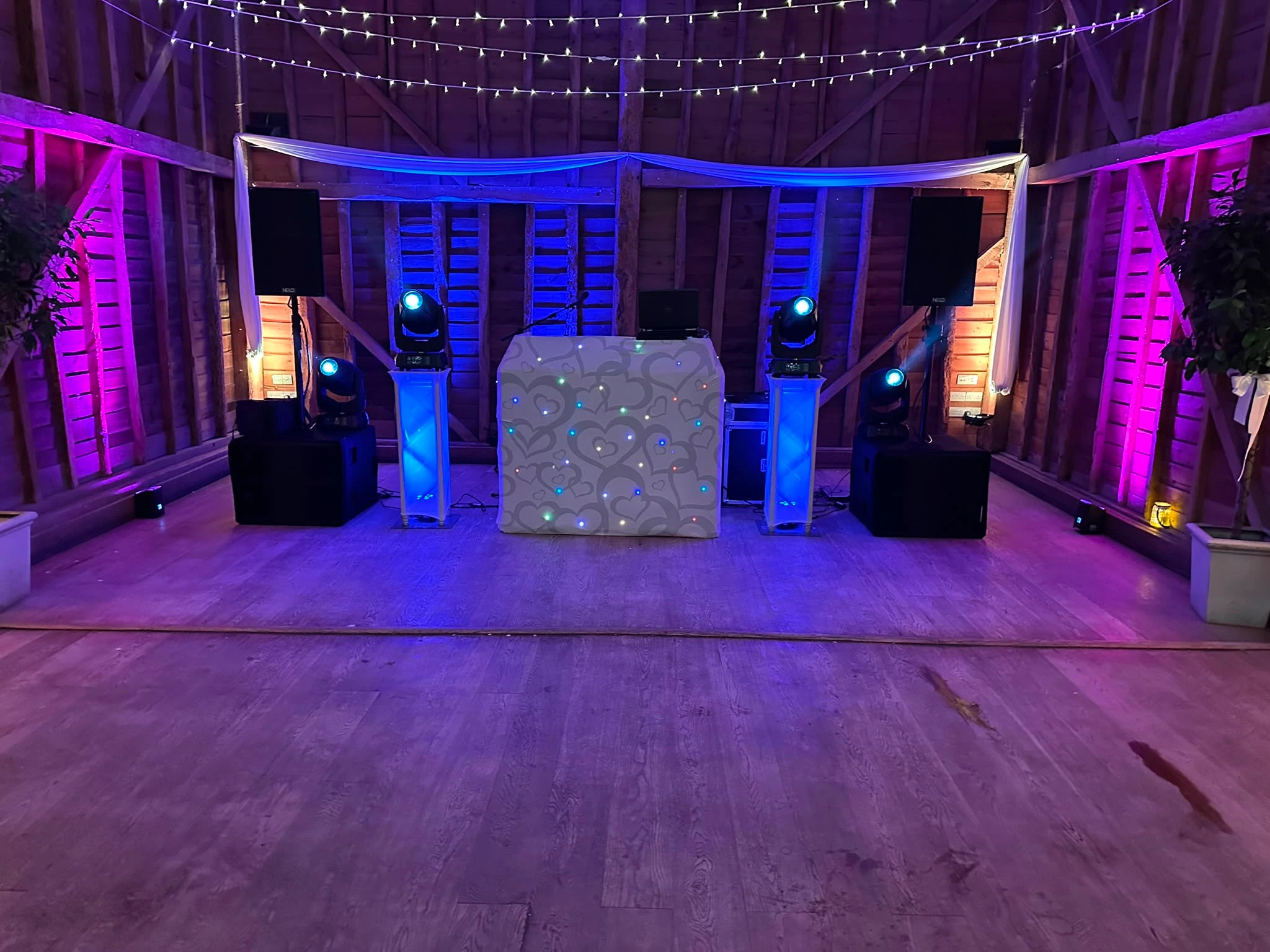 White booth and drapes under a barn's timber frame