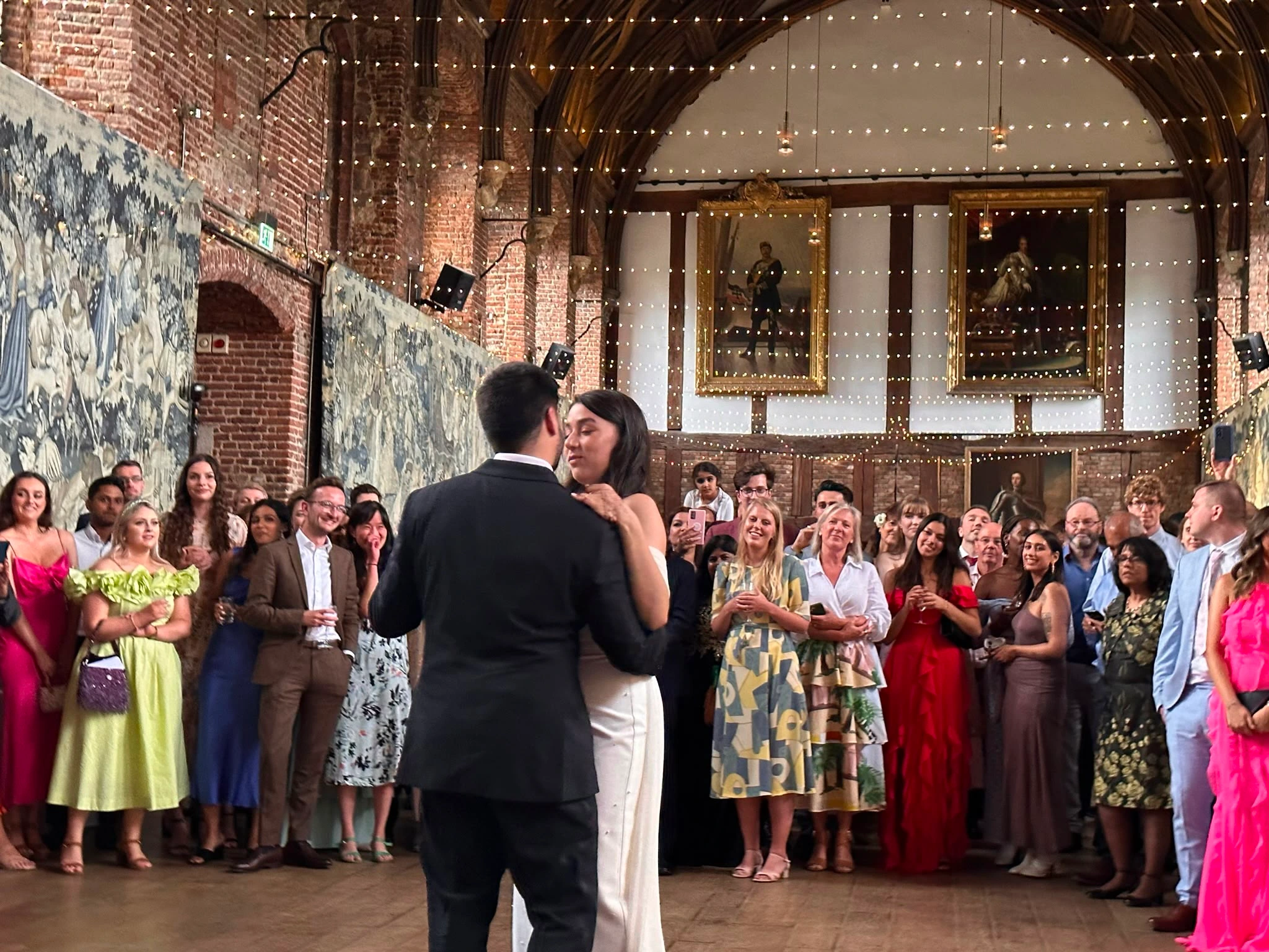 First dance in a tapestry-hung great hall, guests circled round