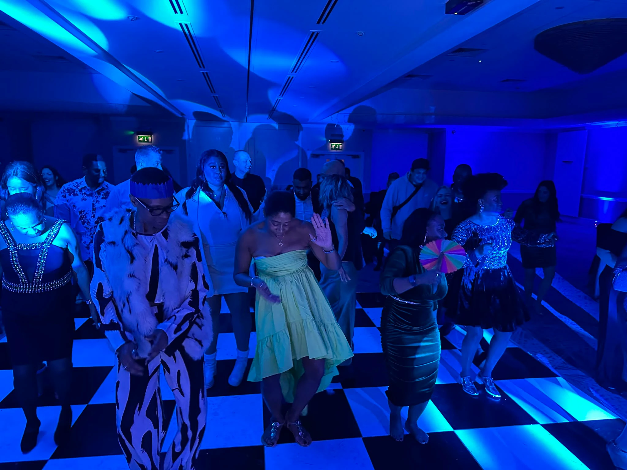 A checkerboard floor packed under deep blue wash lighting