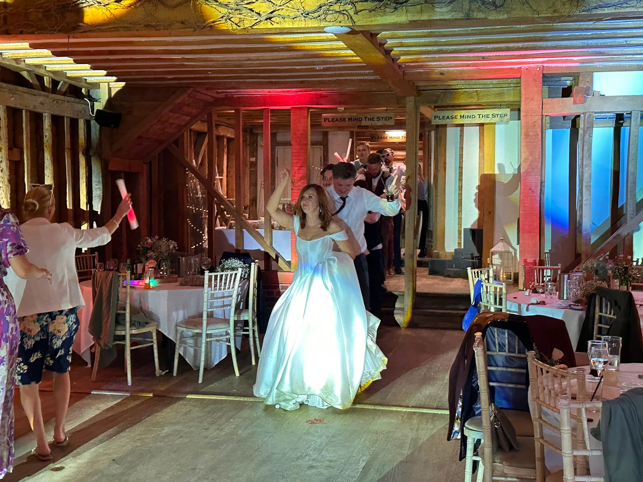 The bride dancing with glow sticks in a barn