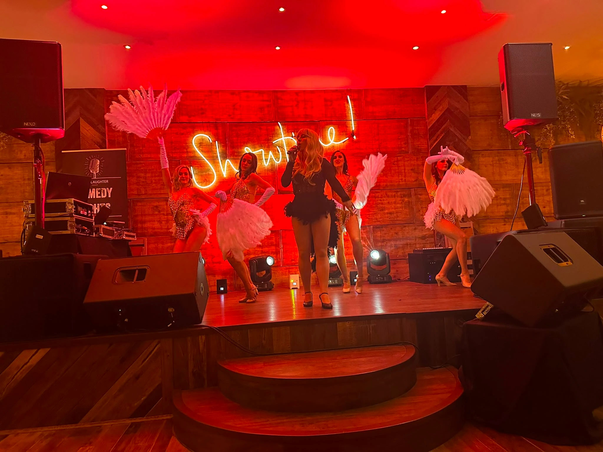 A cabaret act on stage under a Showtime neon sign
