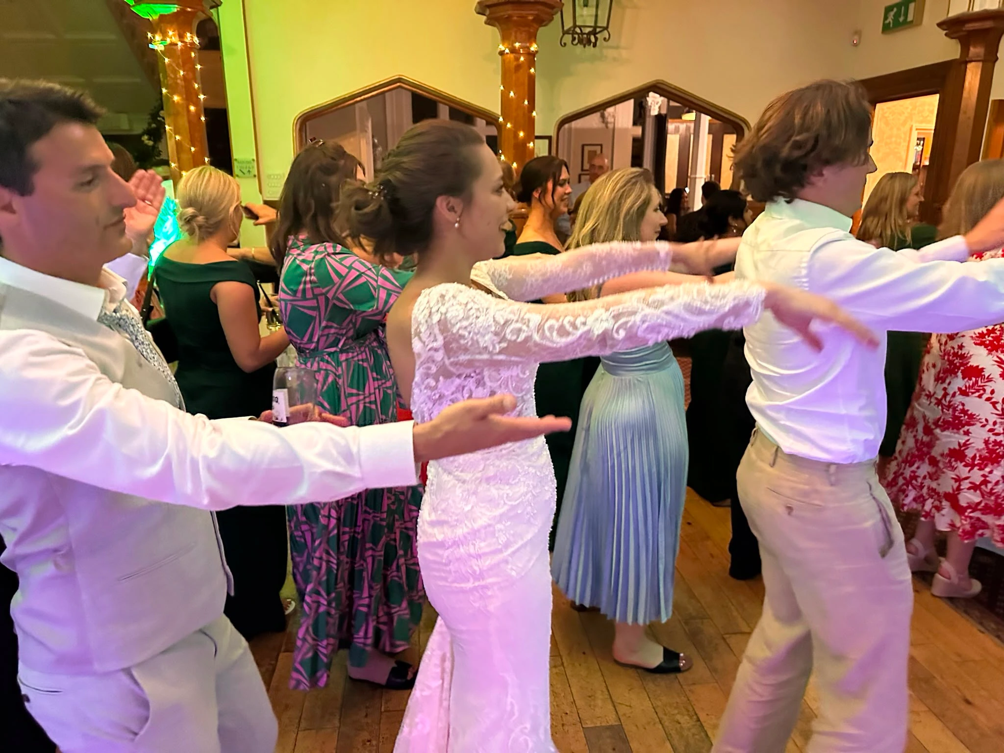 A dance line snaking through a warmly lit room