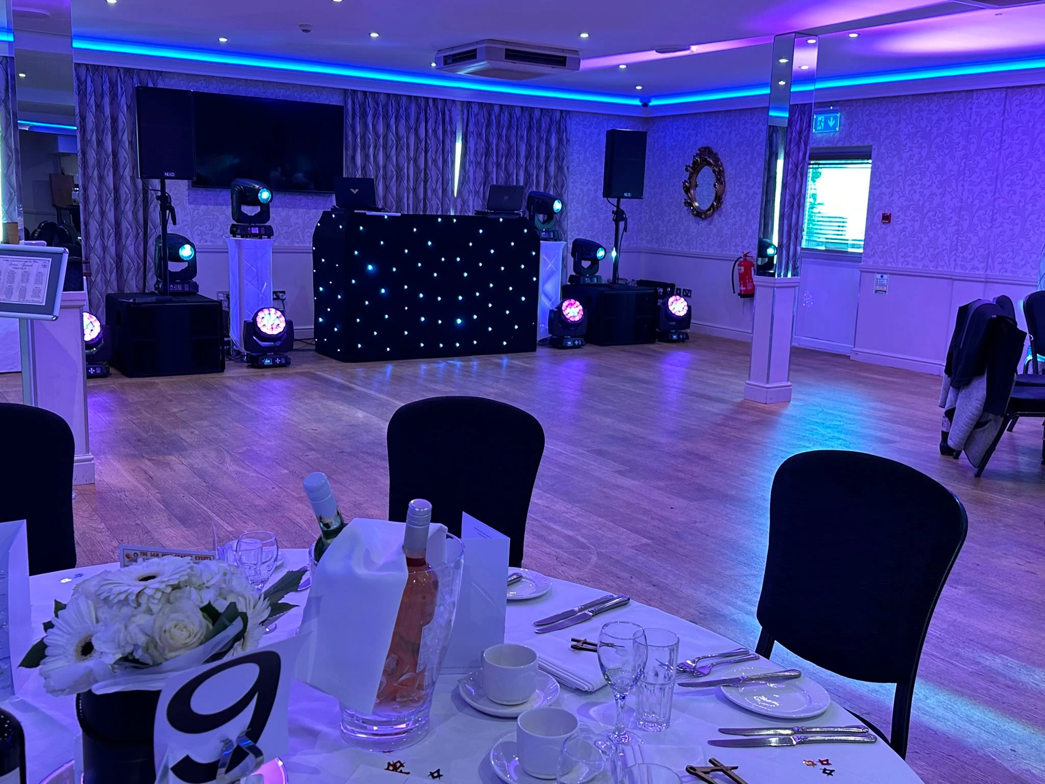 Black star booth and moving heads in a blue-lit function room