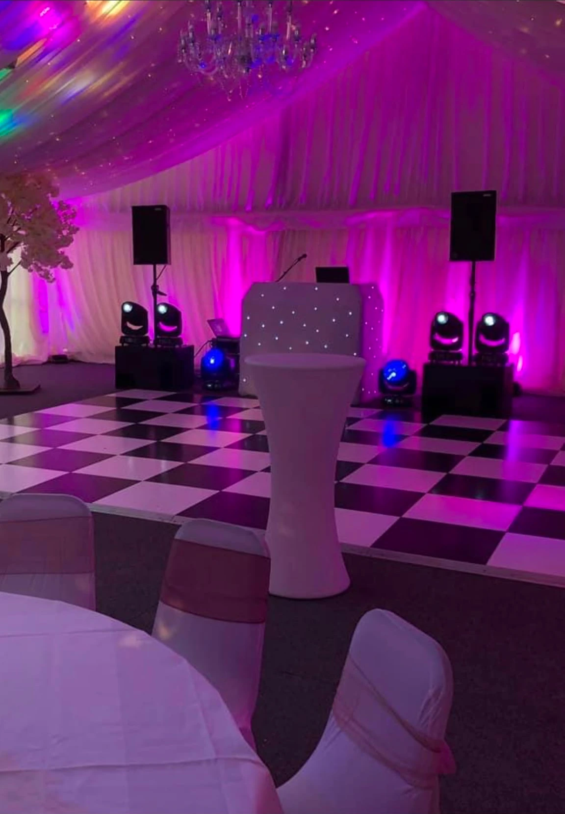 Marquee dance floor under pink lighting with a crystal chandelier