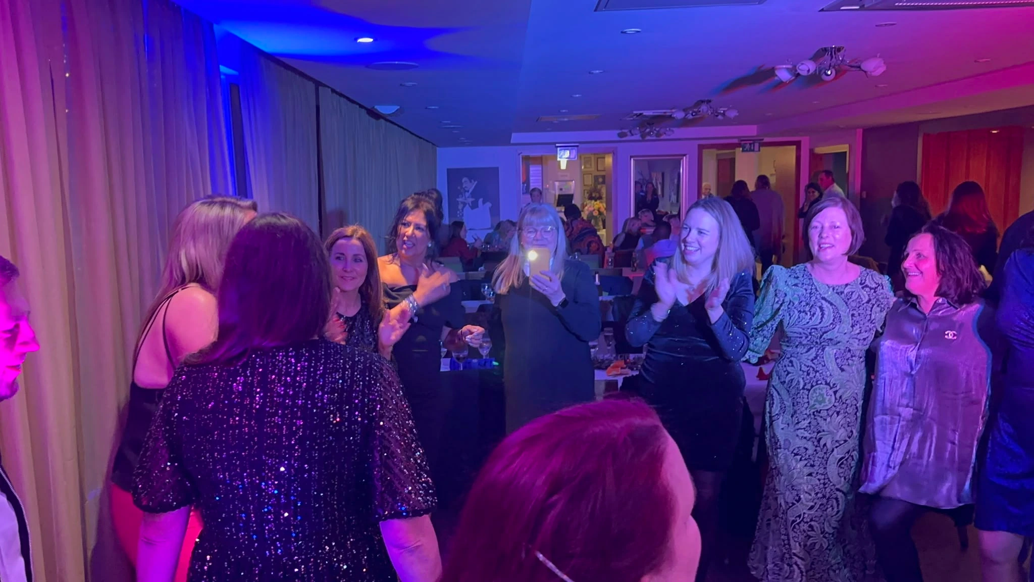 A room mid-party under coloured wash lighting