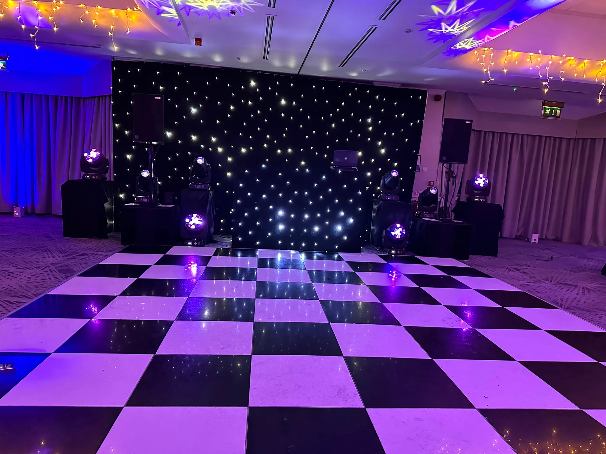 Black star cloth backdrop behind a checkerboard dance floor