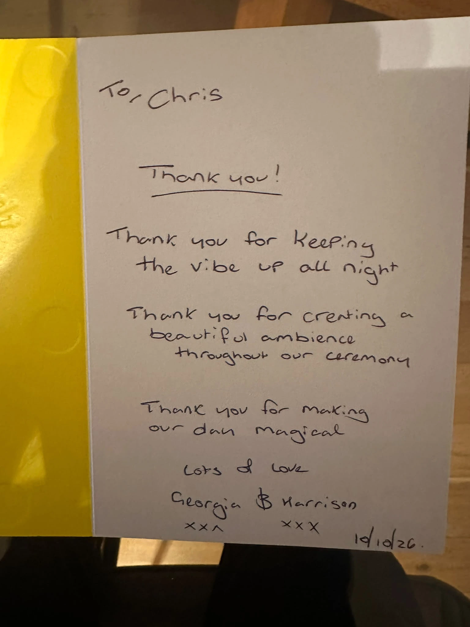 A handwritten thank-you card from Georgia and Harrison, propped up on a table