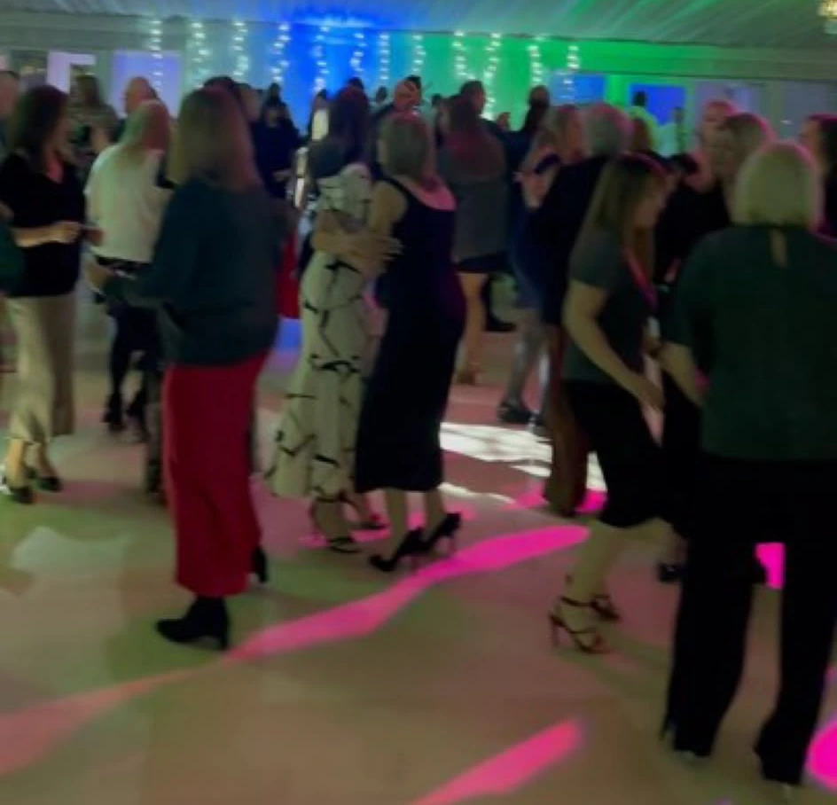 A marquee floor busy under fairy lights