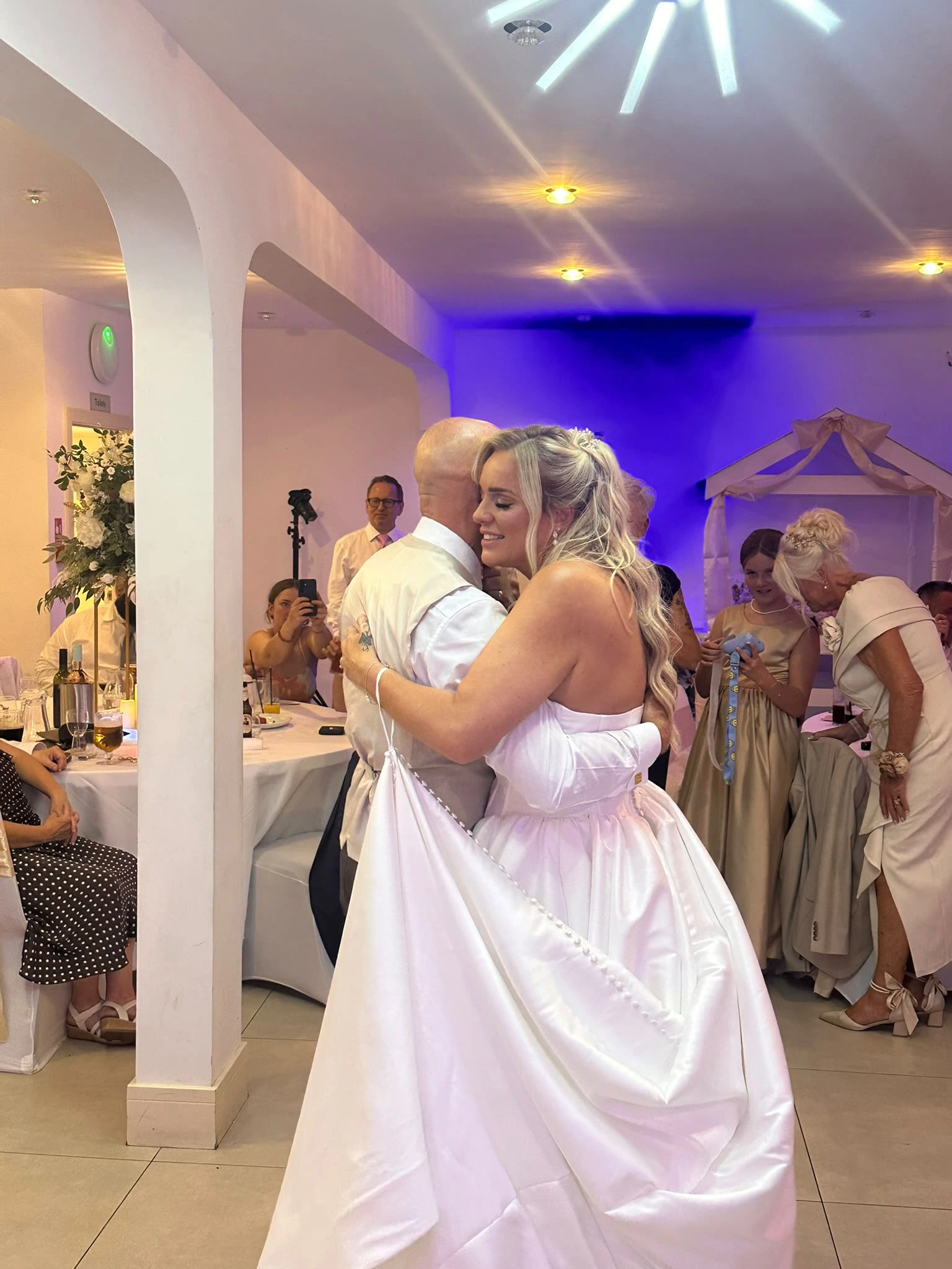 The couple holding each other through the last of their first dance