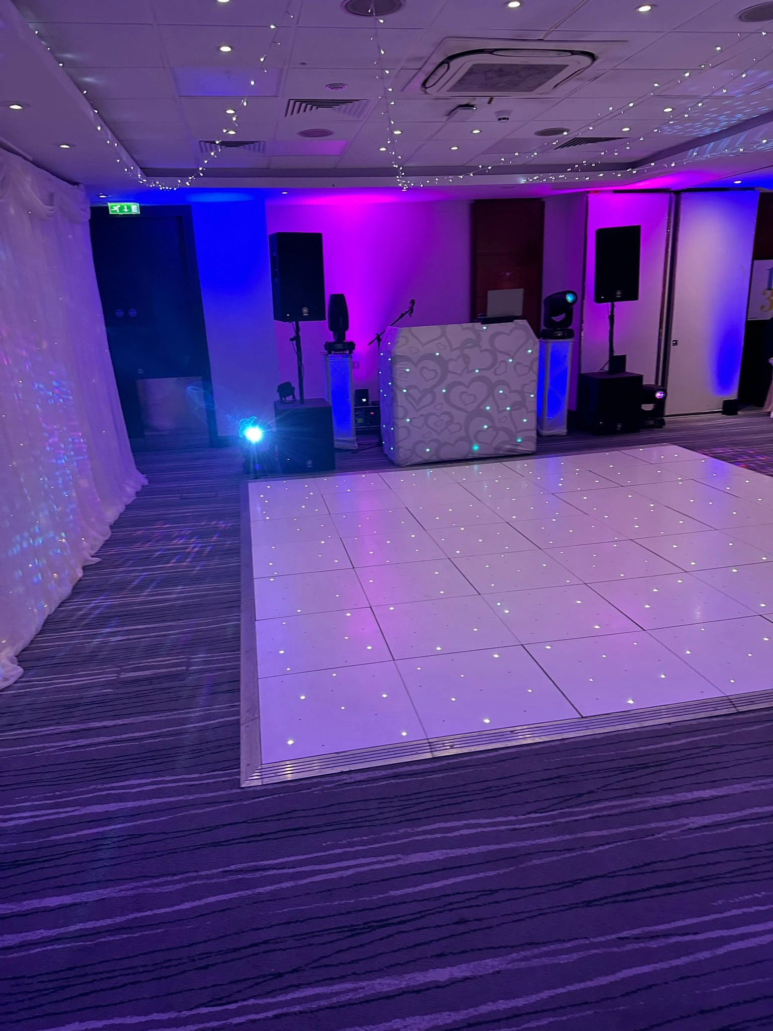 A white starlit dance floor, booth and moving heads set and waiting in a hotel function room